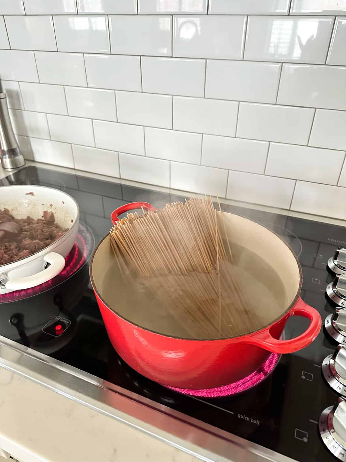spaghetti noodles cooking in large pot of hot water