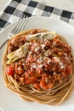 spaghetti and meat sauce over noodles on serving plate