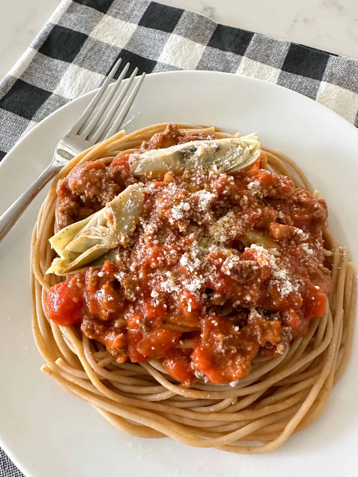 spaghetti and meat sauce over noodles on serving plate