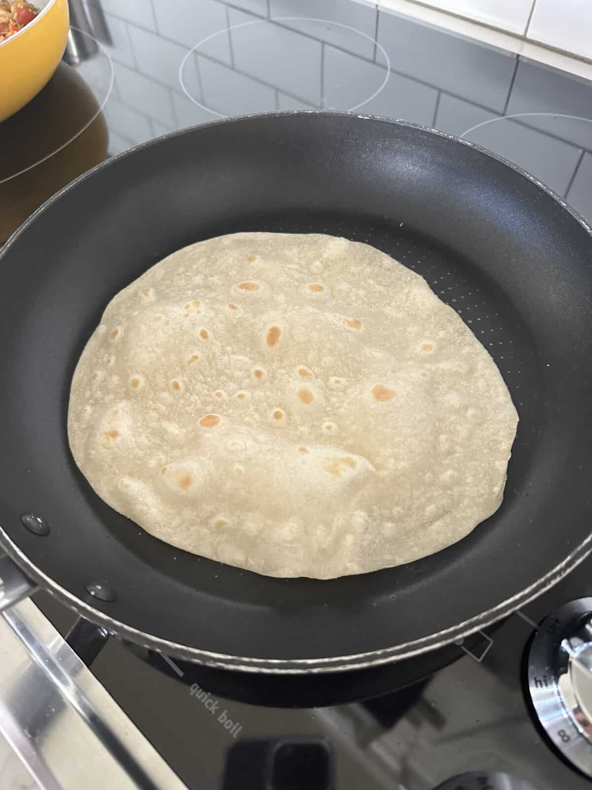 cooking a tortilla in a skillet