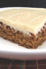 A slice of gingerbread bar topped with cream cheese frosting.