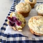 Five Blackberry Muffins on a Piece of Parchment Paper