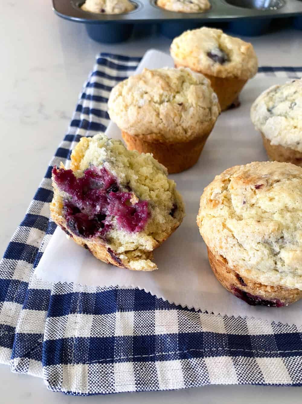 Five Blackberry Muffins on a Piece of Parchment Paper
