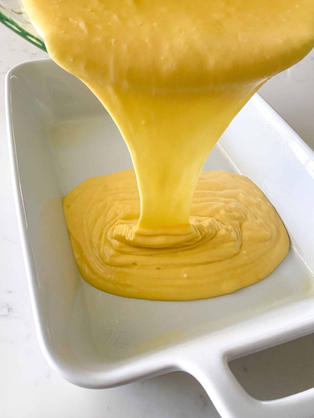 pouring coffee cake batter in cake pan