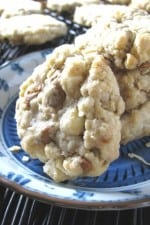 A plate full of cinnamon and white chocolate oatmeal chippers cookies.