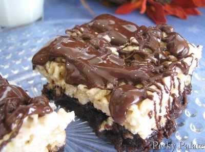 A piece of Crispy Caramel Brownie Treats with a brownie layer on the bottom, a Rice Krispy layer above it, and a drizzle of chocolate on top.