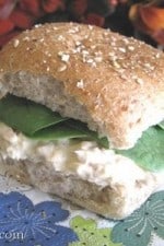 An Easy Tuna Fish Sandwich served on a whole wheat roll with fresh spinach.