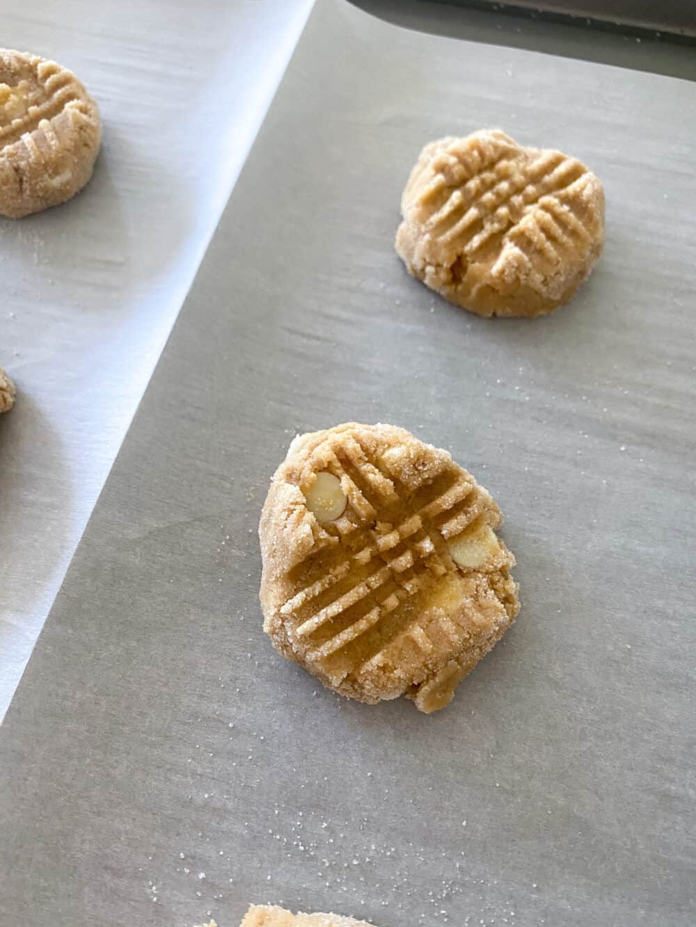 Two Unbaked Apple Peanut Butter Cookies on a Baking Pan