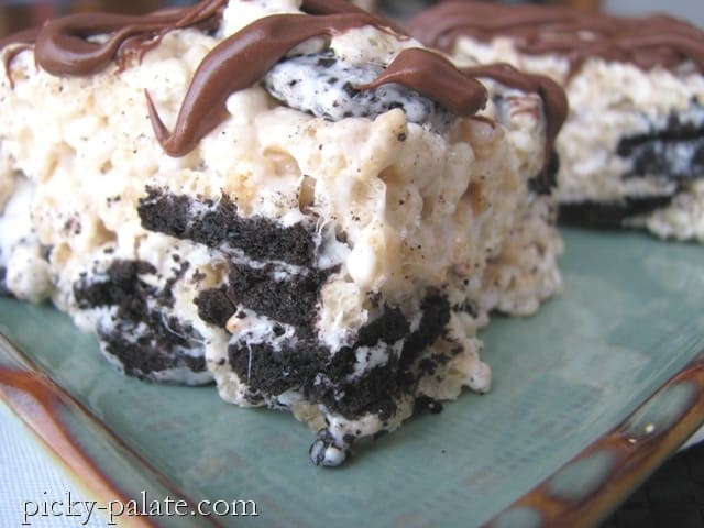 A Cookies and Cream Rice Krispie Treat filled with Oreos and drizzled with chocolate.