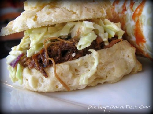 A Close-up View of a BBQ Pulled Pork Sandwich with Creamy Coleslaw Inside