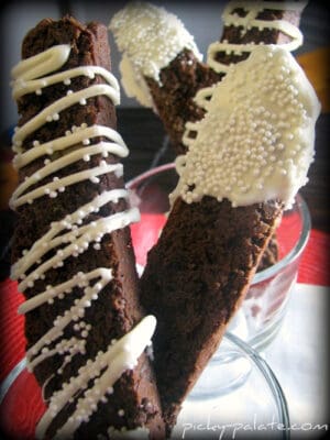 Chocolate Mint Truffle Biscotti coated in white chocolate drizzle and topped with white sprinkles.