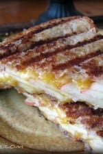 Apple cheddar panini sliced in half on a plate.