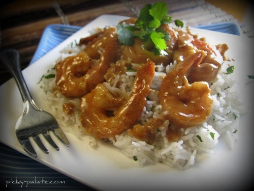 Plate of almond glazed shrimp over a bed of rice.