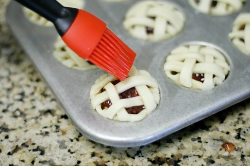 Egg is brushed over the lattice crusts on mini peanut butter and jelly pies.