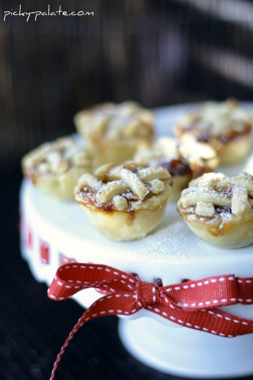 Peanut butter and jelly mini pies with lattice crusts, arranged on a cake stand.