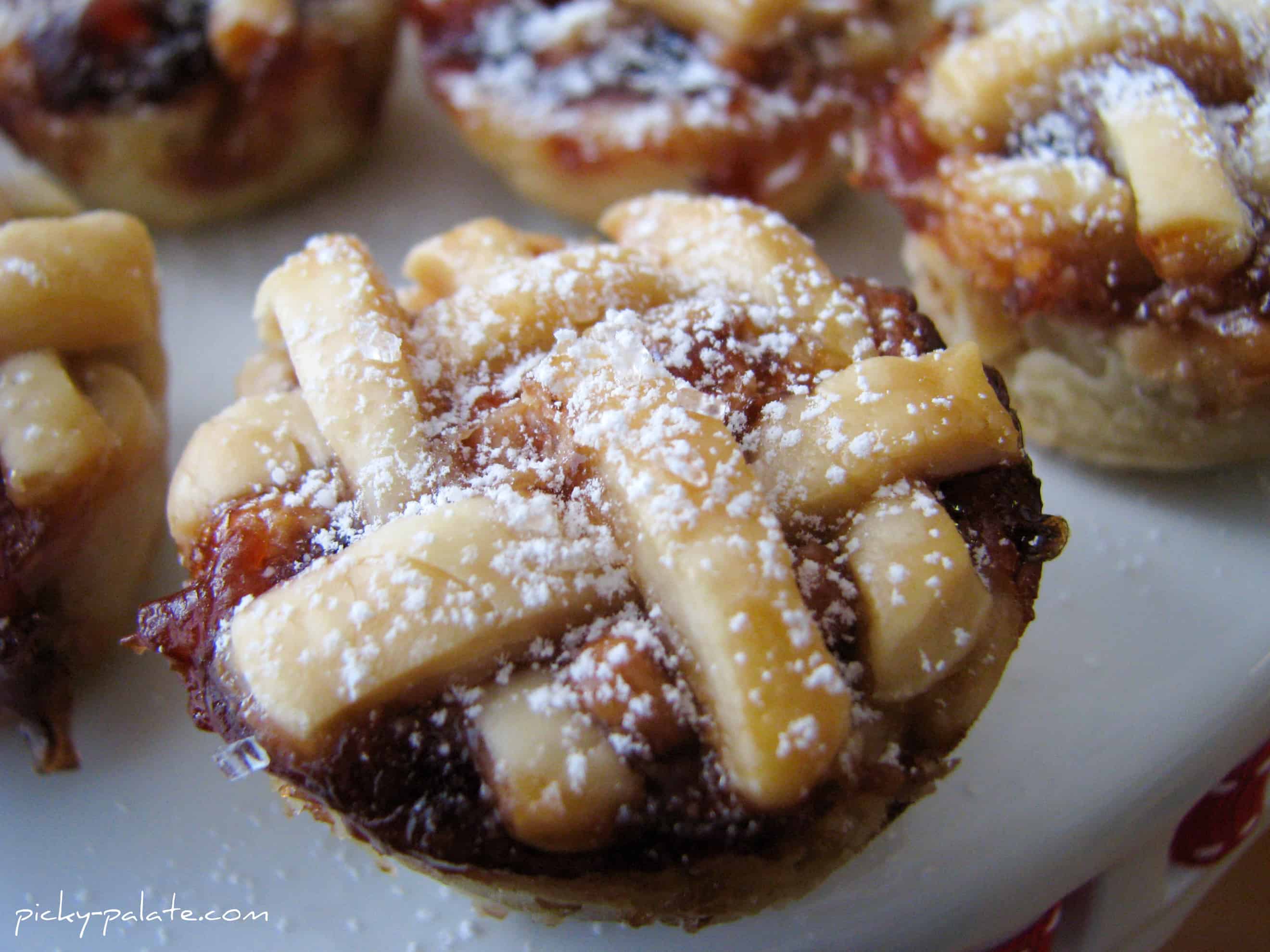 Close up of a baked peanut butter and jelly mini pie dusted with powdered sugar.
