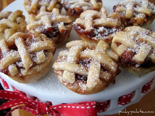 Peanut butter and jelly mini pies with lattice crusts, arranged on a cake stand.