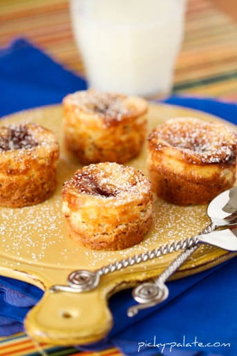 Peanut butter and jelly cheesecake bites on a wooden serving board.