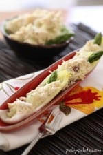 Endives topped with goat cheese, chicken salad and asparagus tips on a narrow serving dish.