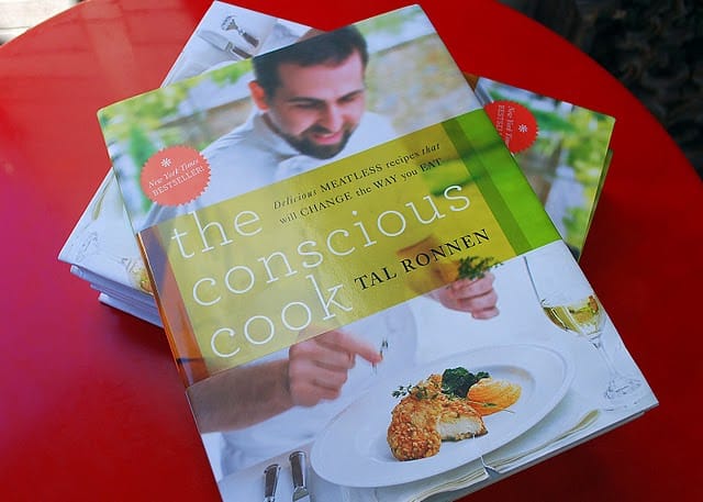 A Copy of The Conscious Cook by Tal Ronnen on a Small Red Table