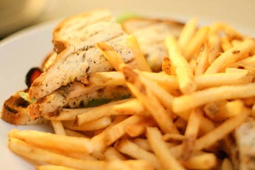 A Chicken Club Sandwich on a Plate with Fries