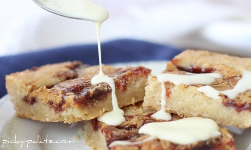 Peanut butter and jelly shortbread cookie bars are drizzled with glaze.