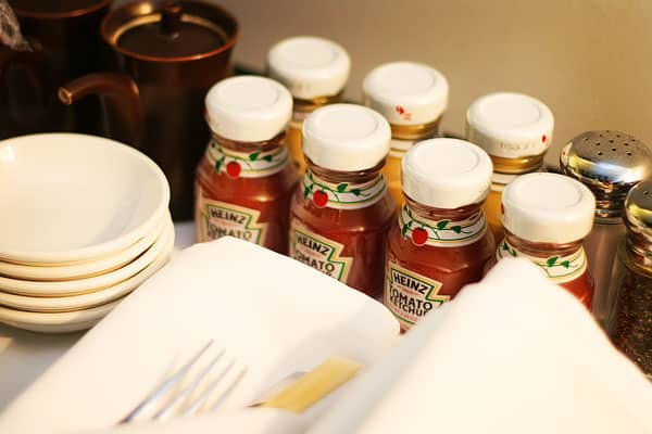 Heins Ketchup and Mustard Bottles Beside a Stack of Five Bowls