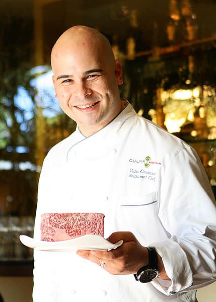 Chef Victor Casanova Holding a Square of Kobe Beef and Smiling