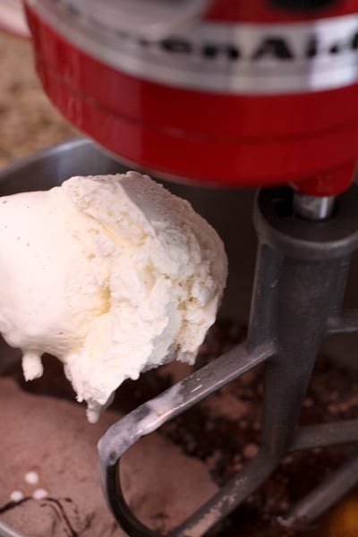 Ice cream is added into chocolate cake batter in the bowl of a stand mixer.