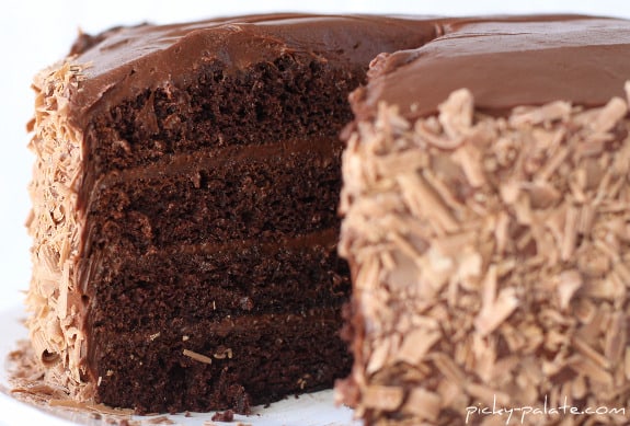 A 4-layer chocolate cake with a slice missing, showing the layers.