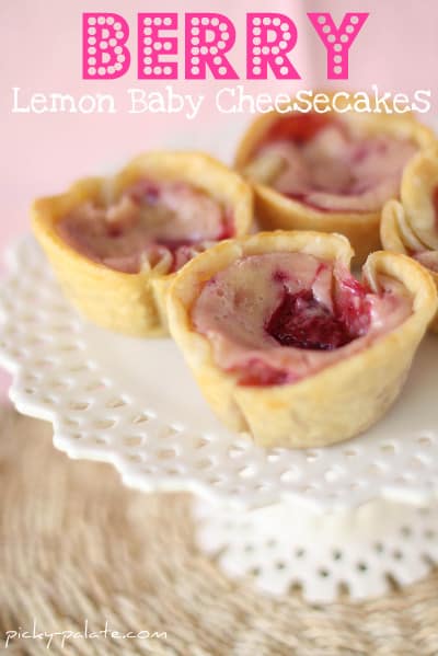 Lemon baby cheesecakes with red and golden raspberries.