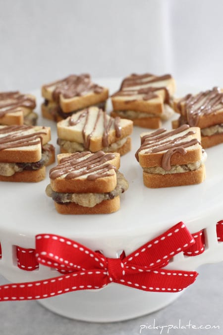 Mini chocolate chip sandwiches drizzled with chocolate on a cookie platter.