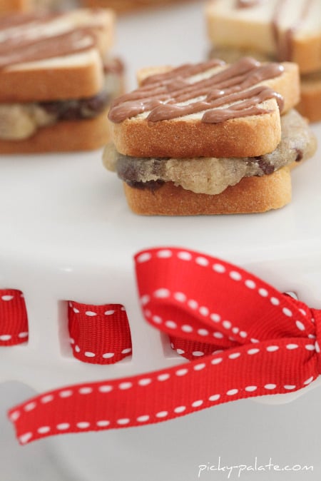 Mini chocolate chip sandwiches drizzled with chocolate on a cookie platter.