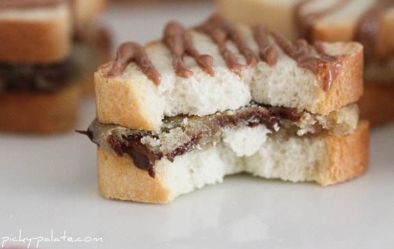 Mini chocolate chip sandwich drizzled with chocolate, with a bite missing.