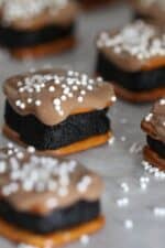 Oreo Cheesecake Pretzel Bites topped with white sprinkles on parchment paper