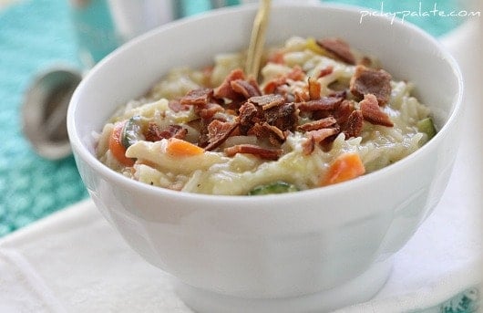 A white bowl filled with cheesy bacon chicken and rice soup