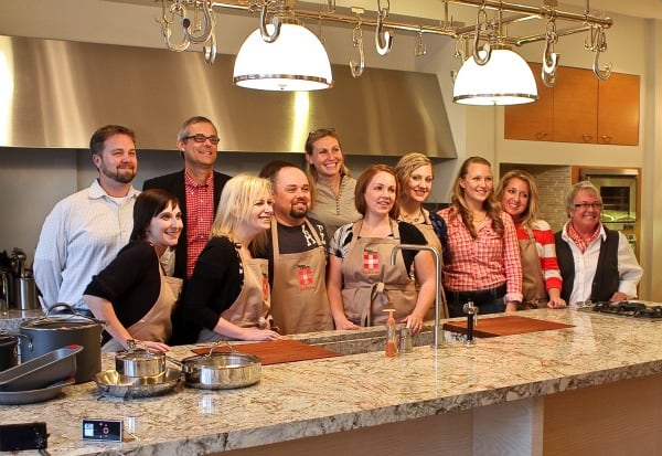 A Group Photo of the Cook-Off Judges, PR People and Contestants Behind a Counter