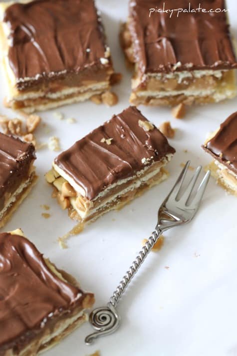 A piece of cake on a plate with a fork and knife, with Chocolate and Caramel