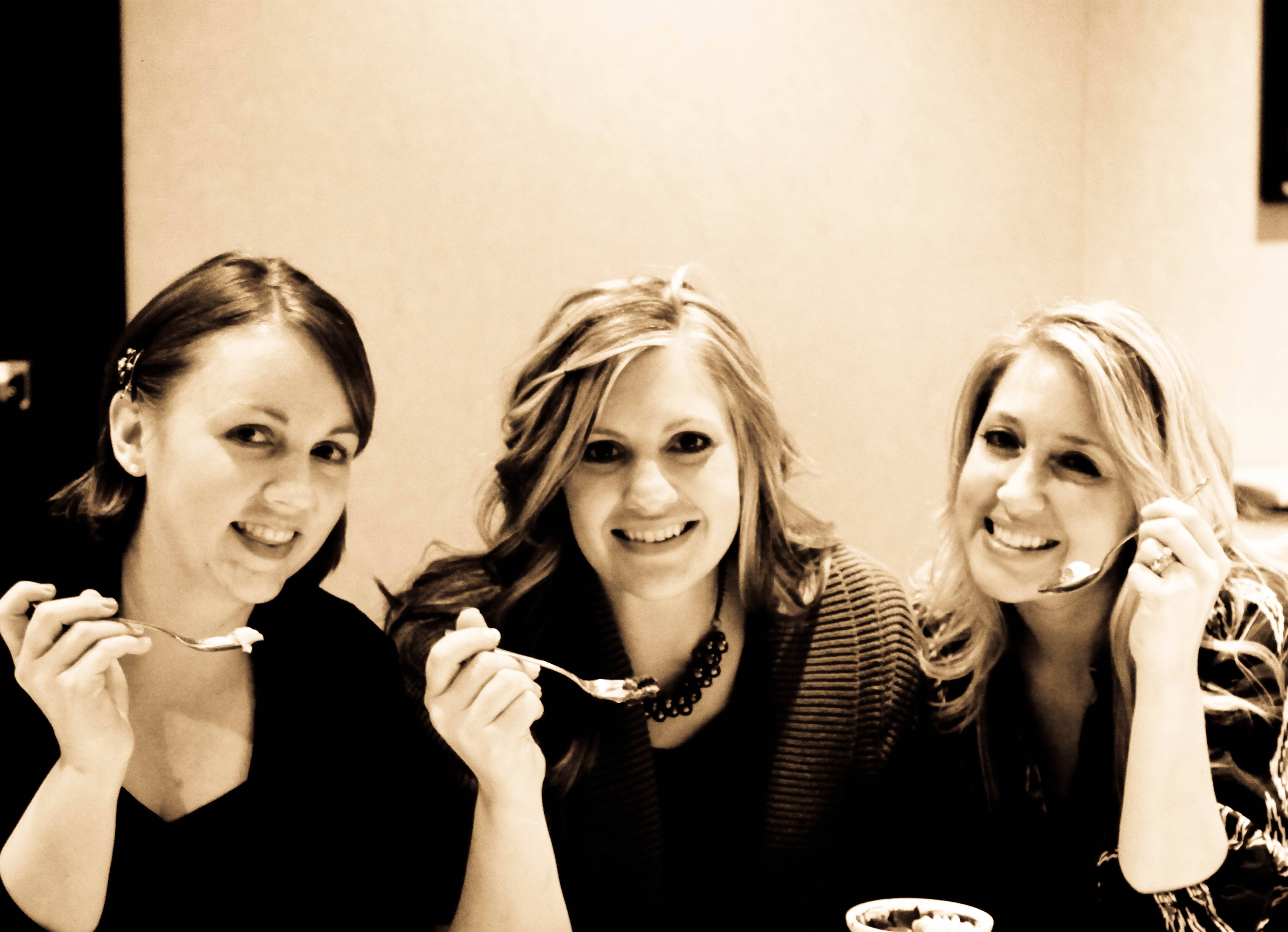 A Sepia Image of Three Food Bloggers Posing with Full Spoons