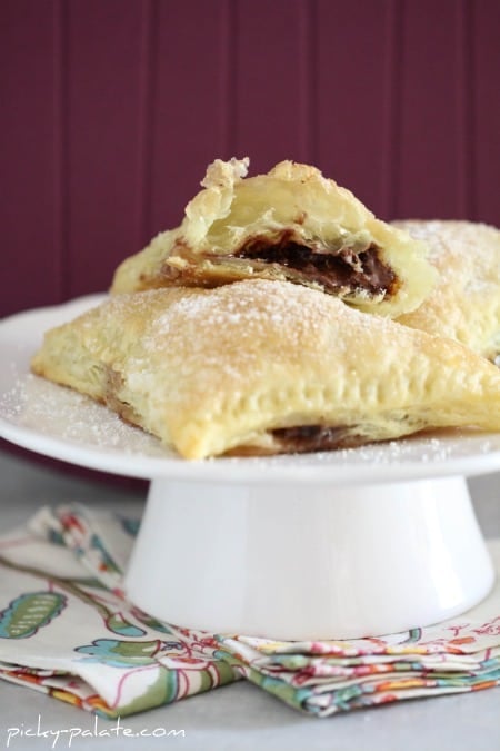 Triangular turnover filled with nutella and marshmallow on a cake stand.
