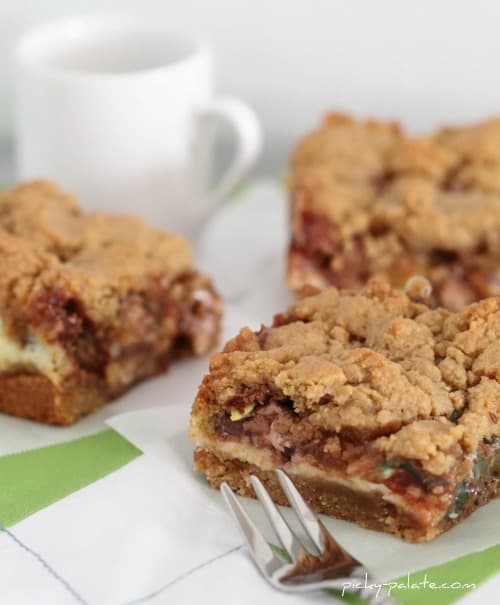 Cream cheese peanut butter cookie bars next to a coffee mug and a fork.