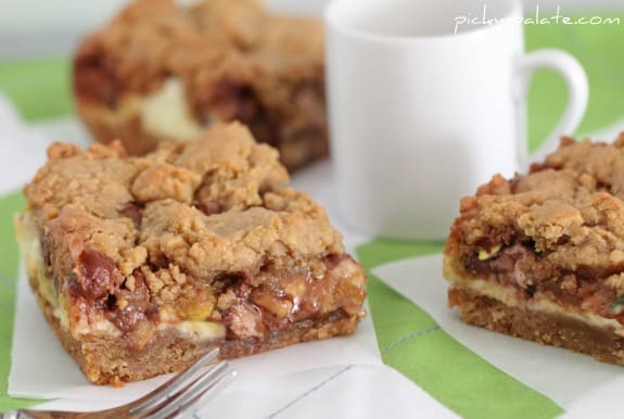 Cream cheese peanut butter cookie bars next to a coffee mug and a fork.