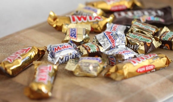 Mini wrapped Halloween candy bars on a cutting board.