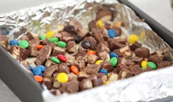 Candy spread over the cream cheese and cookie layers in a baking pan.