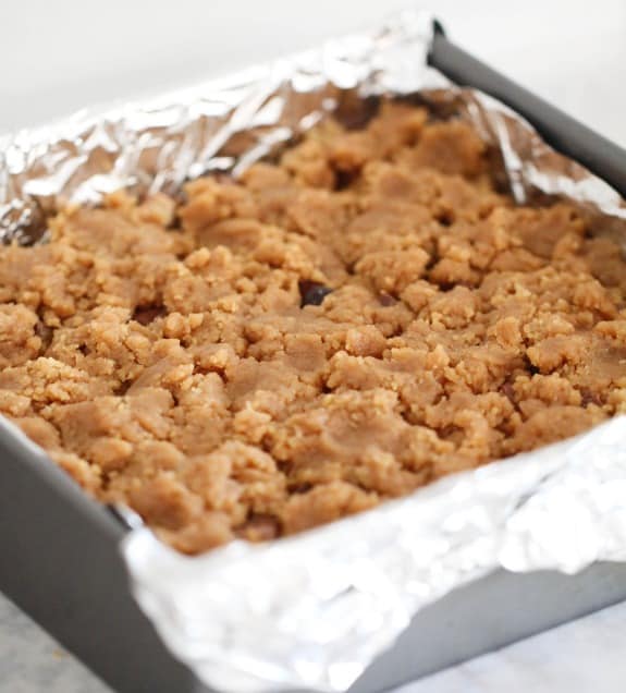 Peanut butter cookie dough layered in a baking pan.