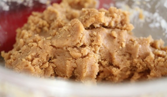 Close up of peanut butter cookie dough in a glass bowl.