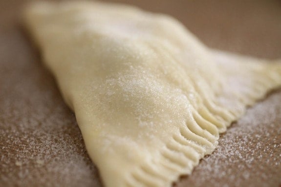Close up of a turnover pastry with crimped edges.