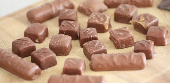 Unwrapped chocolate candy on a cutting board.