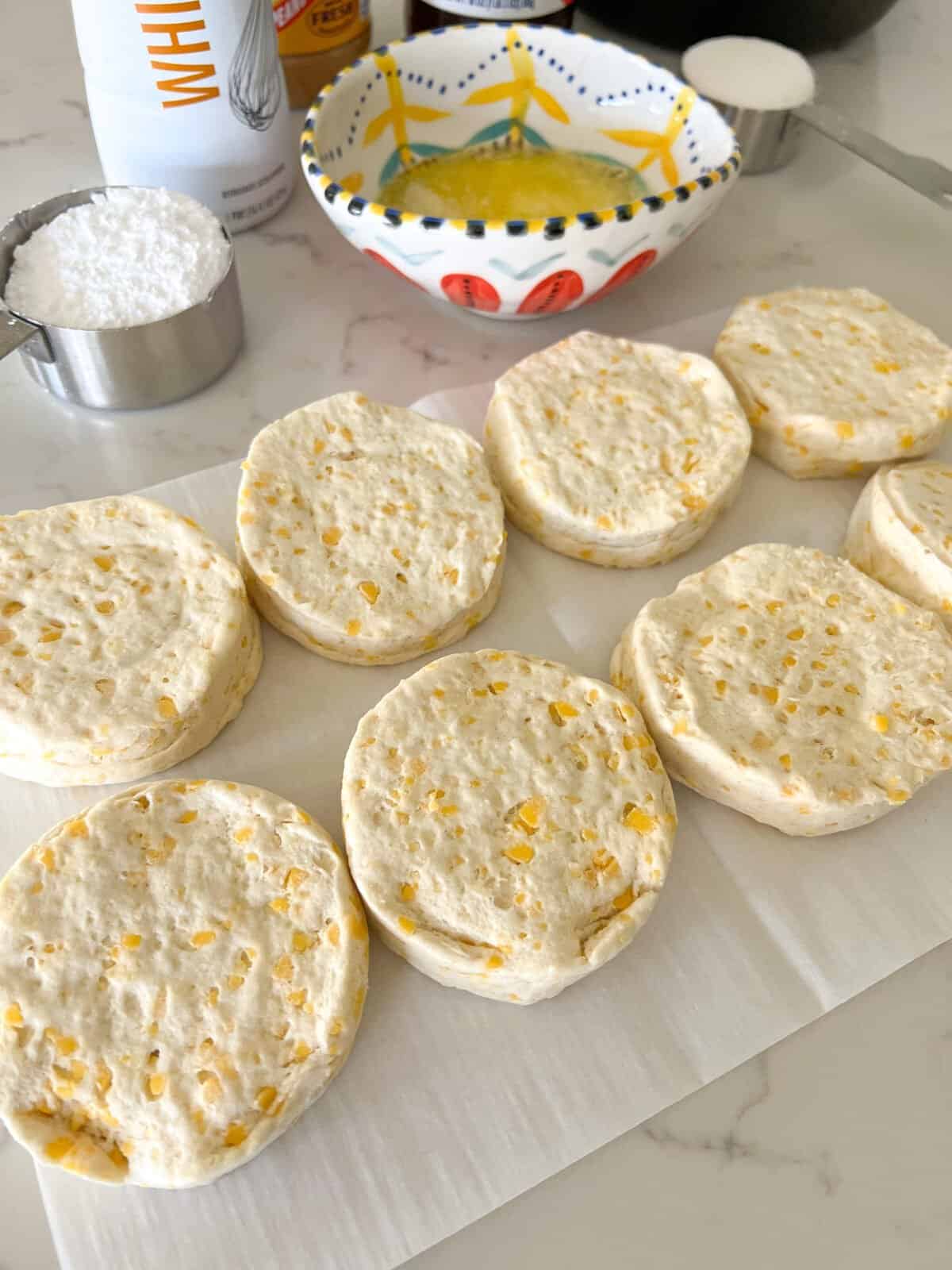 biscuits placed onto parchment paper on counter
