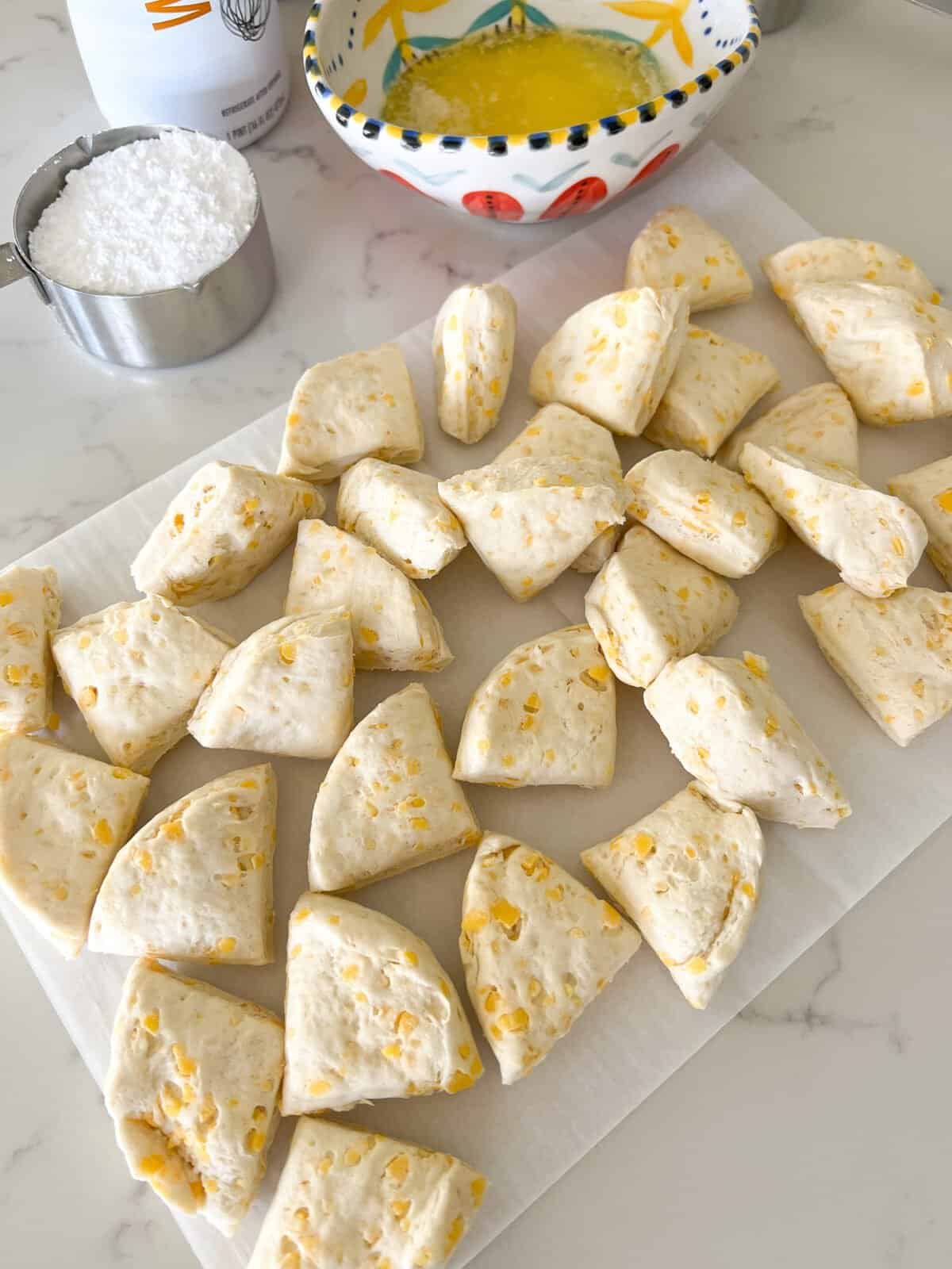 biscuits cut into fourths on parchment paper